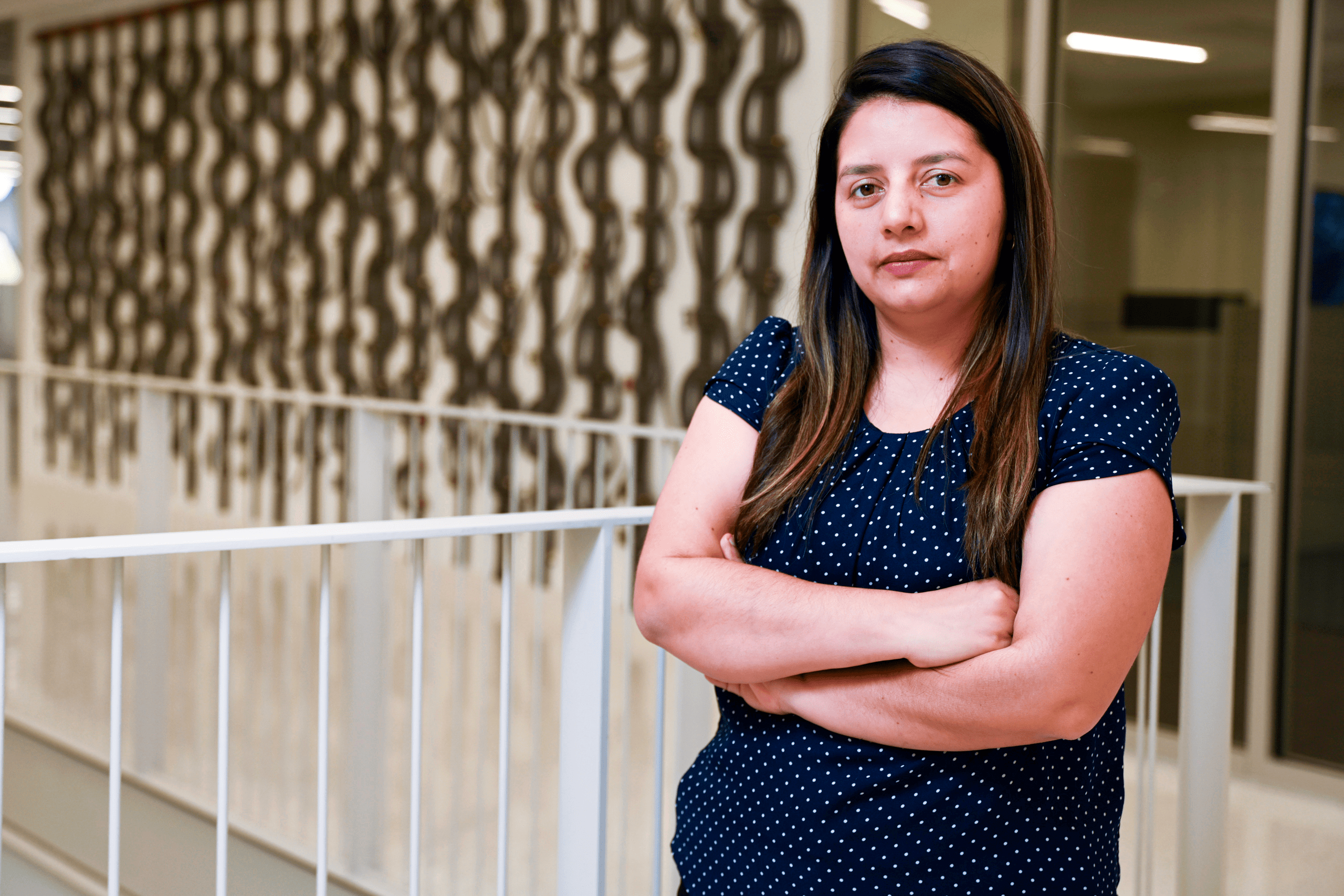 Laura Cruz Castro posing with her arms crossed on the 5th floor of the Malachowsky building at UF.